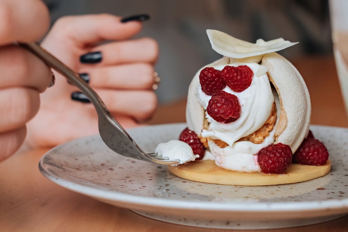 Professional dessert plating with fresh berries and whipped cream