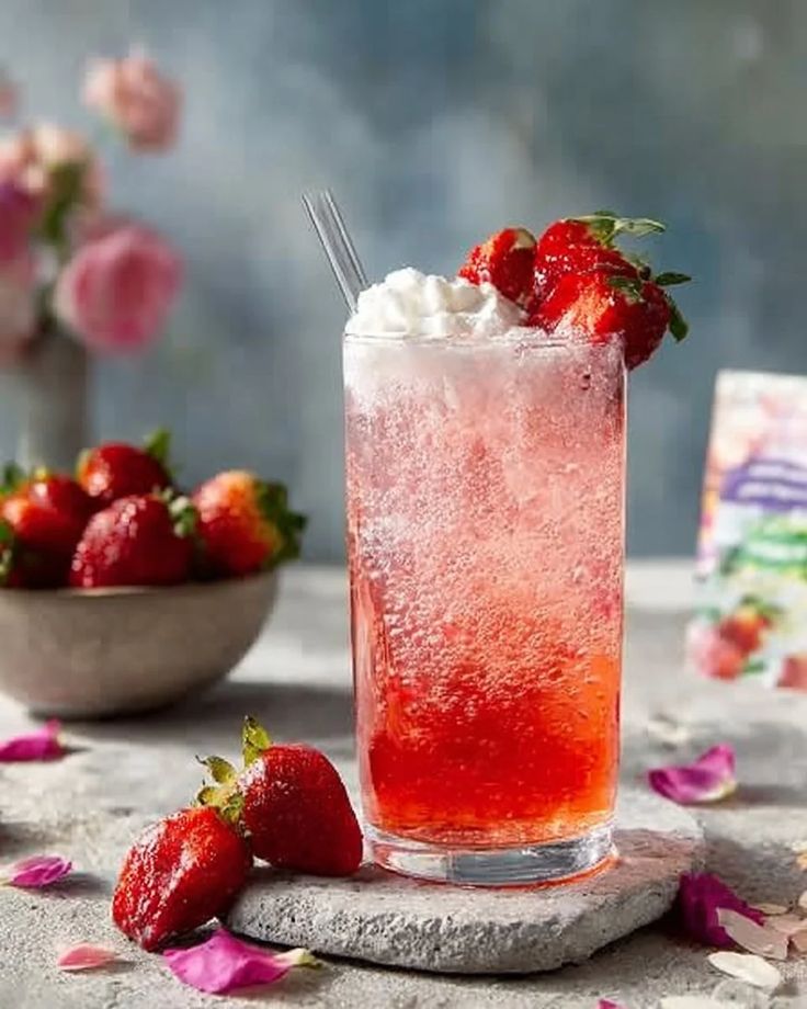Strawberry gin fizz cocktail with fresh berries and herb garnish