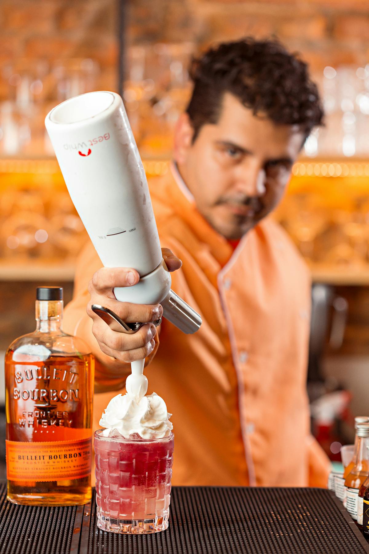 Bartender using cream dispenser for whipped cream